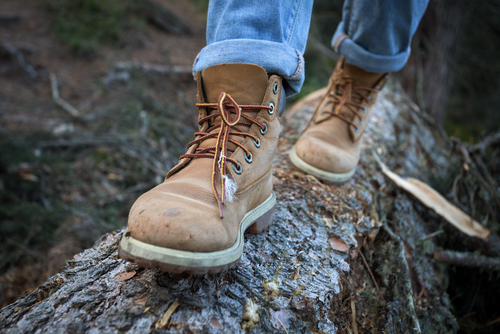 hiking boots close-up. girl tourist steps on a log